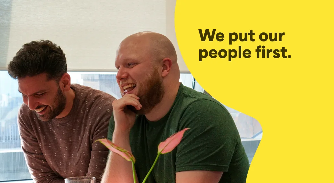 A photo of two Trustpilot employees laughing. It has a text overlay that says We put our people first.